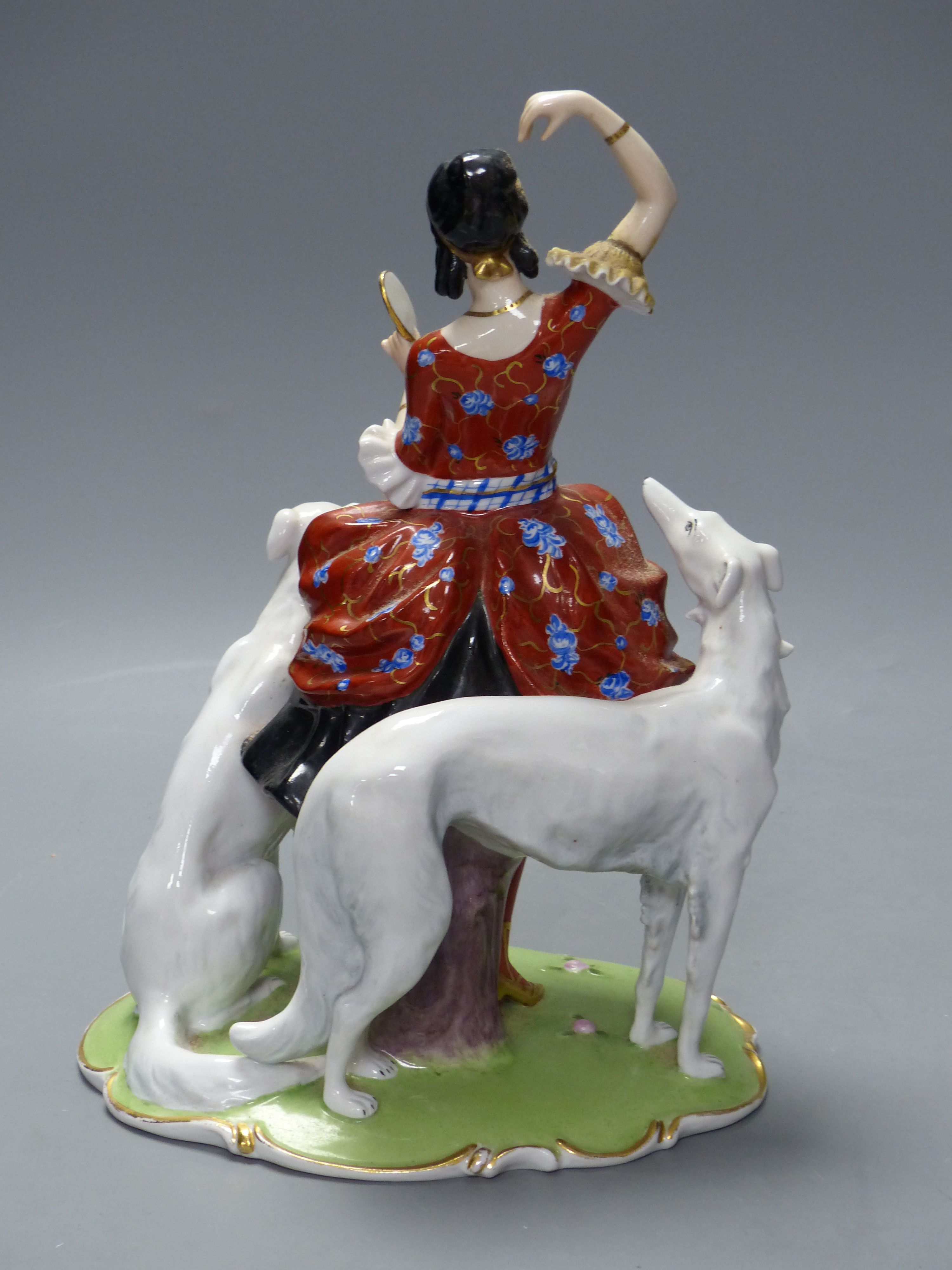 An Art Deco Fraureuth group modelled as a lady wearing a red gown flanked by two Borzoi dogs, H 28cm